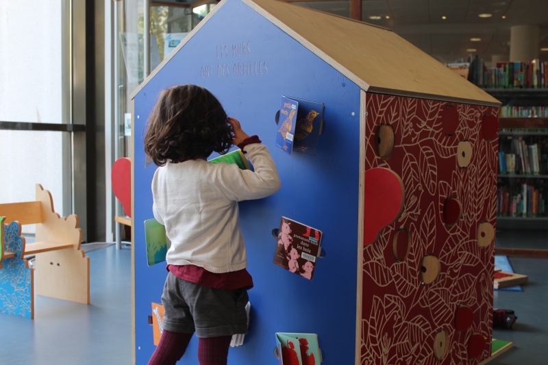 Une petite fille joue avec la cabane de l'exposition 
